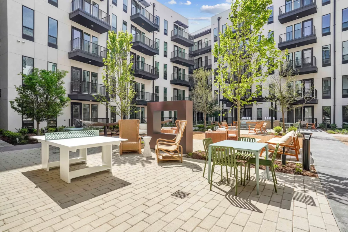 Outdoor courtyard with lounge chairs, fireplace, and ping pong table.