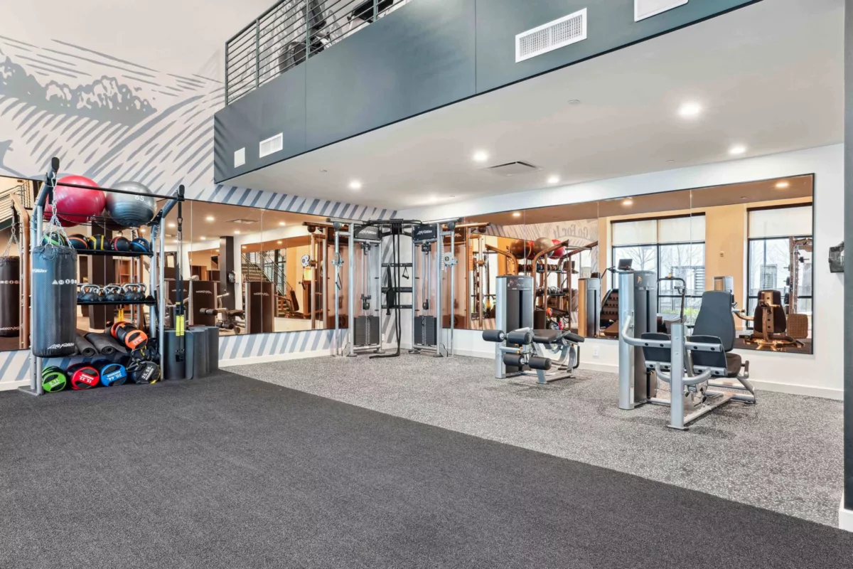 Spacious fitness center with strength machines, mirrors, and organized equipment.