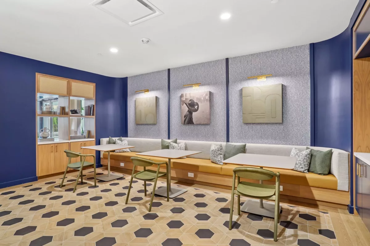 Library-style room with wall art, banquette seating, and geometric floor tile.