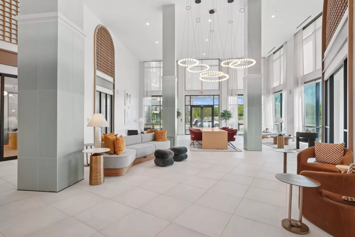 Spacious lobby with modern seating, tall windows, and ring pendant lights.