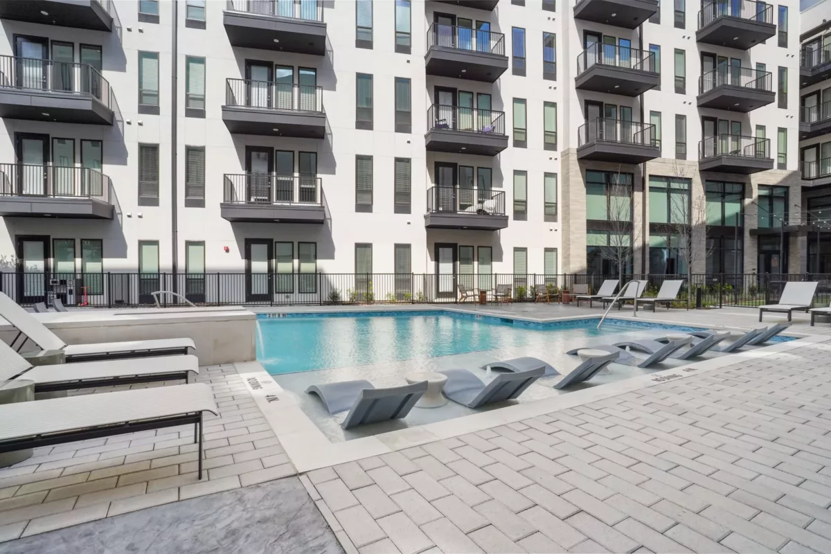 Courtyard swimming pool with in-water loungers and surrounding lounge chairs.