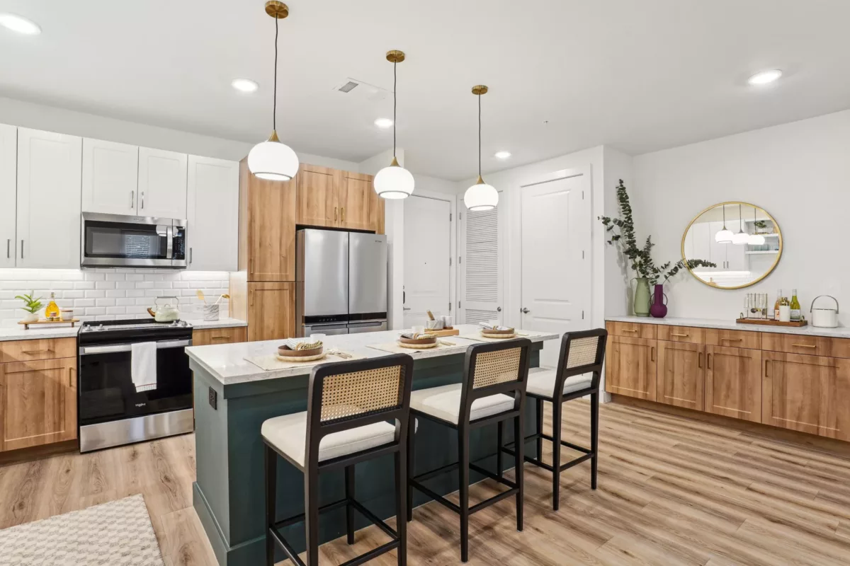 Contemporary kitchen with wood cabinetry, island seating, and globe pendants.